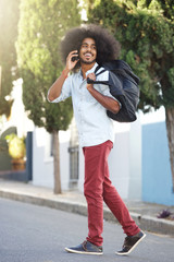 Fototapeta premium happy man walking outside with phone and bag