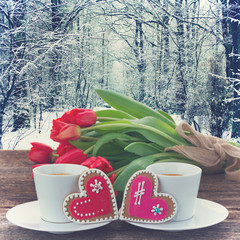 Valentines day coffee with fresh tulips on wooden table with winter backdrop, retro toned