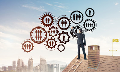 Businessman on house roof presenting teamwork and connection con