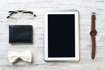 Gentleman kit of tablet watch glasses bow tie and notebook on wooden table
