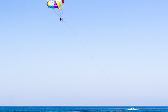 The motorboat rolled tourists on a parachute. Maritime space.
