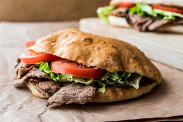 Turkish Pide Doner Sandwich with greens and tomatoes.