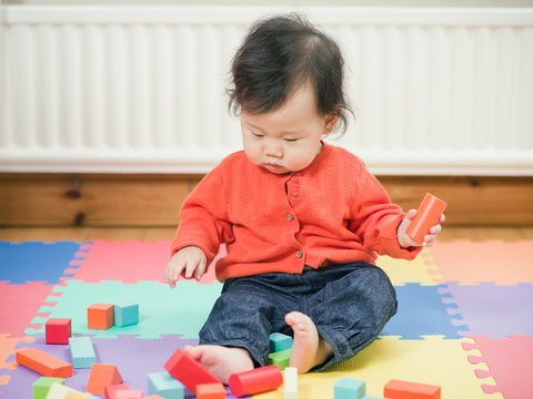 Asian baby playing building blocks
