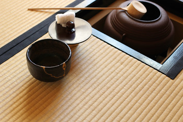 Obraz na płótnie Canvas 日本の茶室にある茶釜と金継ぎされた黒い抹茶茶碗