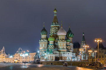 Obraz premium Russia, Moscow. View on a Red Square from the Moskvaretsky bridge, St. Basil Cathedral on the right, State Department Store is on the right. Evening, snow, winter.