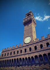 Fototapeta na wymiar FLORENCE Old Palace and clock tower with blue sky in Signoria sq