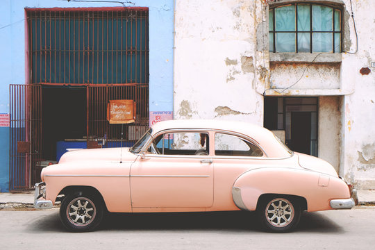 Fototapeta Side view of pink vintage car parked on street