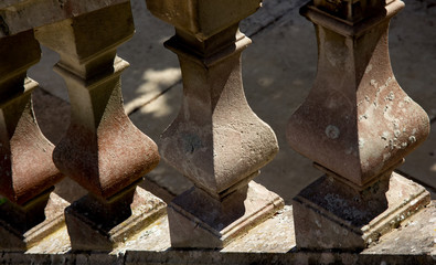 Several old stone balusters. Outdoors. Covered with lichen