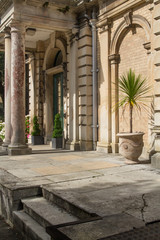 Porch building with columns. Refined Architecture. Palm tree in a pot.