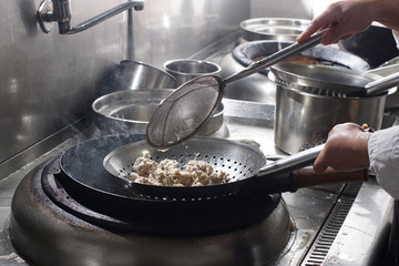 Close up of working chef preparing chinese food