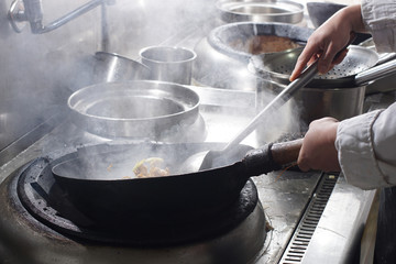 Close up of working chef preparing chinese food