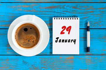 January 29th. Day 29 of month, calendar on blue wooden office workplace background. Winter at work...