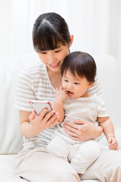 asian mother and baby using smart phone