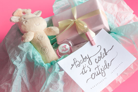 baby's bootees and gift box on wooden background