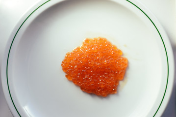 Eggs of red caviar on white surface background. Top view flat lay image