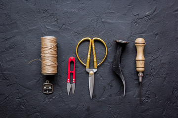 leather craft instruments on dark background top view mock up