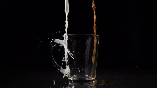 Pouring coffee and milk and making splashes on black background