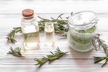 organic cosmetics with extracts of herbs rosemary on wooden background