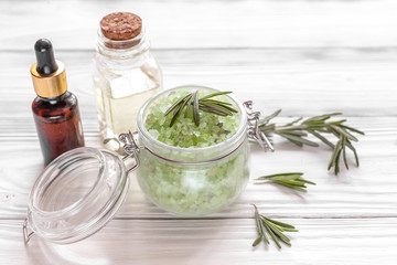 organic cosmetics with extracts of herbs rosemary on wooden background