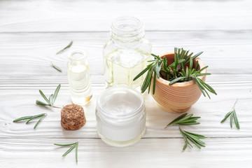 Fototapeta na wymiar organic cosmetics with extracts of herbs rosemary on wooden background