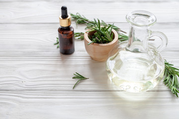 organic cosmetics with extracts of herbs rosemary on wooden background