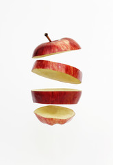 Fresh red golden delicious apple cut into slices floating