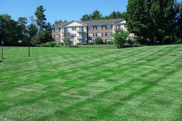 apartment building with large green front lawn