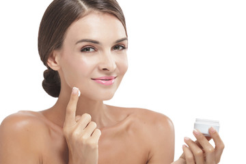 beautiful woman applying some facial cream