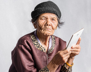 Portrait of a senior woman confused with tablet in vintage costu