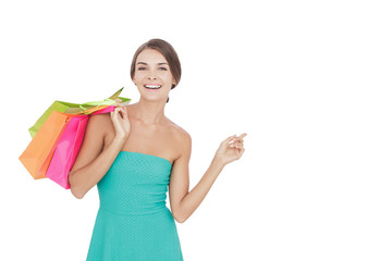Obraz premium beauty woman carrying shopping bags while pointing at copy space