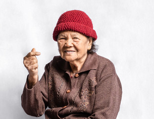 Portrait of a senior woman in a pose mini heart finger with vint