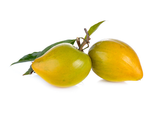 ripe Tiesa or egg fruit with stem and leaves on white background