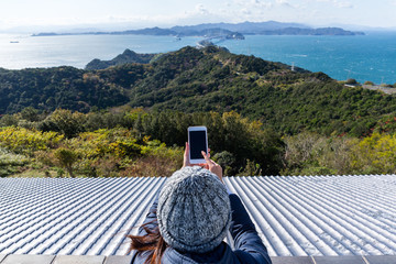 Woman using mobile phone to take photo