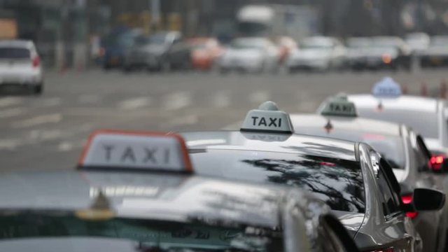 Cars taxi stand in a row on a city street. In the frame of the roof with the signs. Focus moves from front to back. The effect of "living camera"