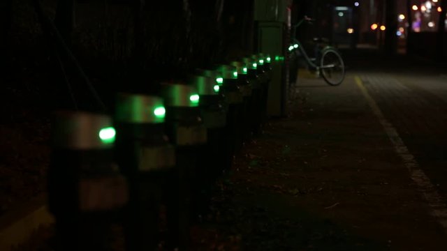 Parking for the rental bikes at night. Focus moves from front to back