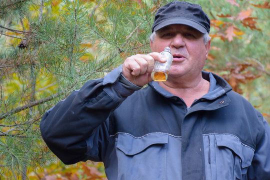 Mature Caucasian Man Drinking Whiskey From A Bottle