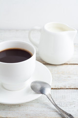 Black coffee in a white cup on a white background