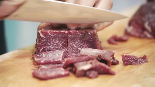 On board a human being cut into chunks with a knife red meat metal.