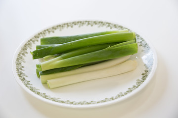 bunch of fresh spring onions a plate