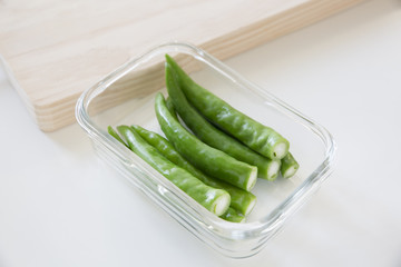 Green chili peppers in a glass container