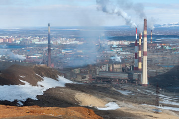 Lots of smoking factory chimneys in the background  the city.