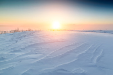 Fototapeta na wymiar Sunny sunrise over the snowy plain.