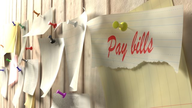 Reminder to pay the bills pinned to kitchen wall