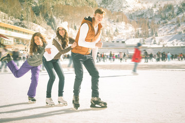 Funny teenagers girls and boy skating outdoor, ice rink