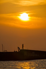 Fototapeta na wymiar 夕陽と釣り人