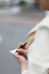 Business Woman Writing with pen in notepad