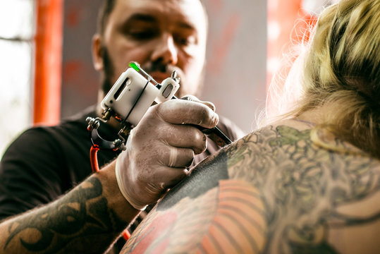the process of creating a tattoo on the back girl