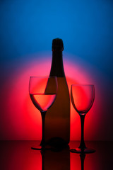 Glasses of champagne and a bottle of wine on a black background
