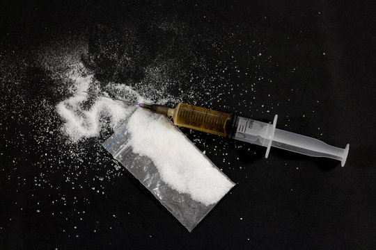 Drug syringe and cooked heroin. Cocaine in the bag, scattered. I