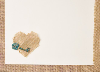 Valentines day love background on textile with a key to the heart